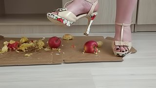 Crush fetish. Puffy legs in high-heeled shoes trample on apples.